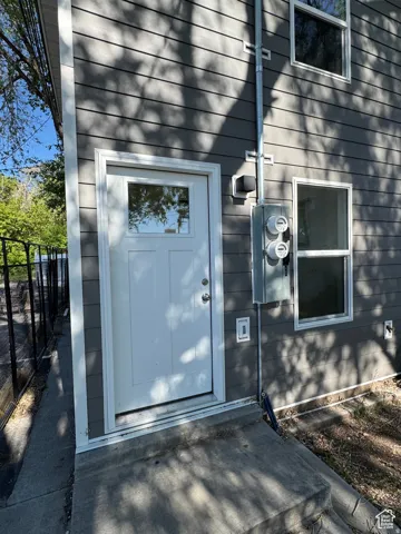 Light blue entry door with sidelite window and transom detail, framed by white trim