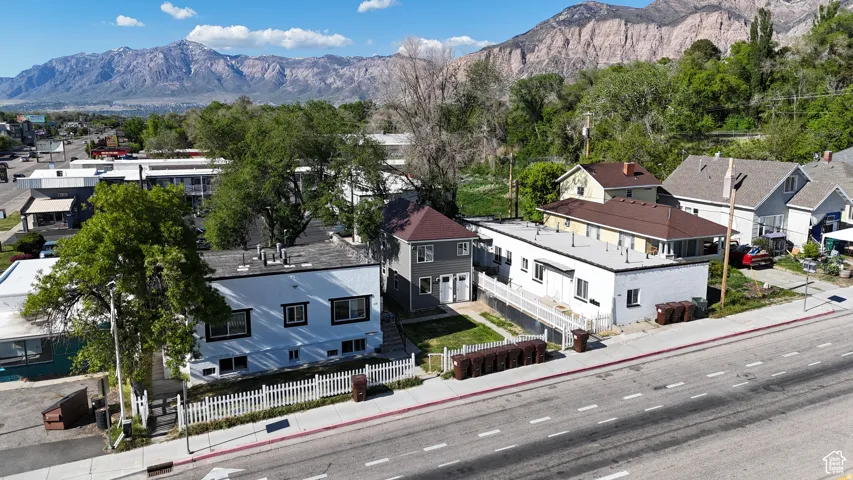 Mixed-use property with a flat roof, white picket fence, and mountain scenery