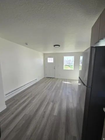 Bright interior with wood-finish flooring, white walls, and a contemporary ceiling light fixture
