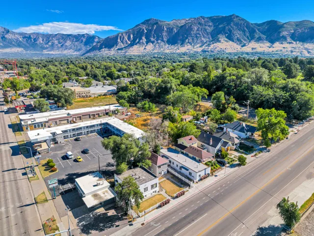 Mountainous backdrop with surrounding mature trees and distinct commercial and residential properties