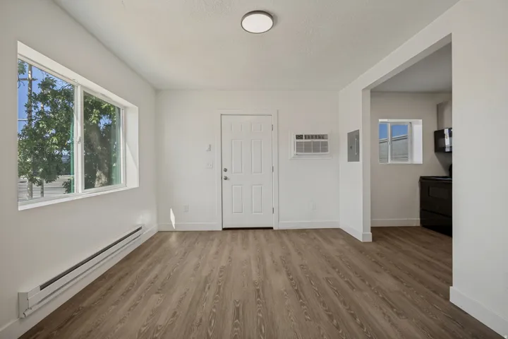 Wood-finish flooring, white walls, and a multi-pane window