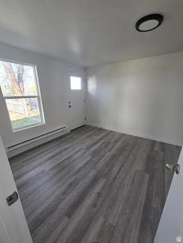 Wood-finish flooring, white walls, and a single window offering natural light