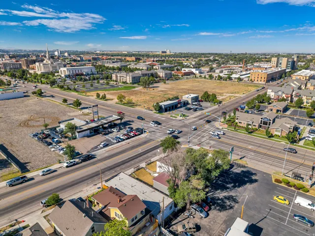 Aerial perspective of a developed urban area featuring a prominent institutional building, commercial structures, and residential properties