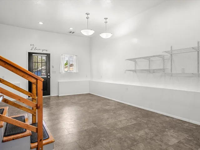 Wood-finish flooring, two semi-flush mount light fixtures, recessed lighting, and built-in wire shelving