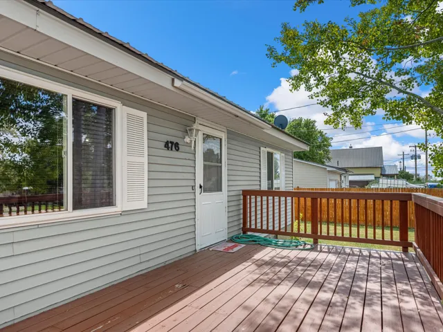 Exterior featuring horizontal siding, white window trim, and a wood-finish deck with a matching railing