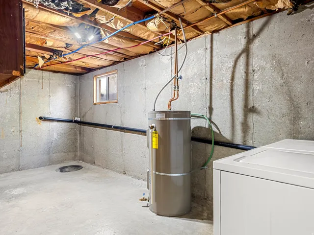 Concrete foundation walls, exposed ceiling joists, and a water heater