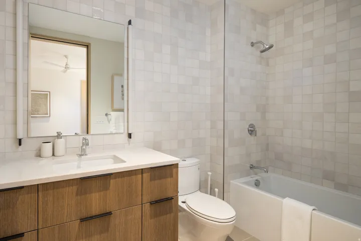 Bathroom featuring a wood-finish vanity with a white countertop and integrated sink