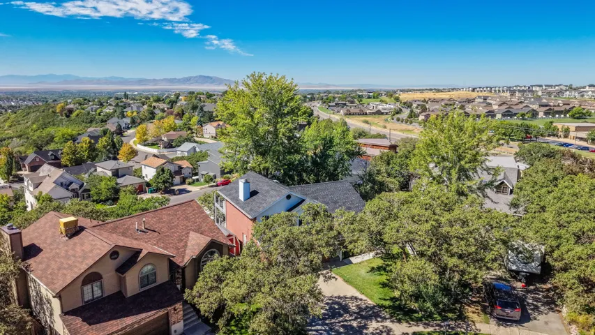 Aerial perspective showcasing residential properties with a mountainous backdrop under a clear sky