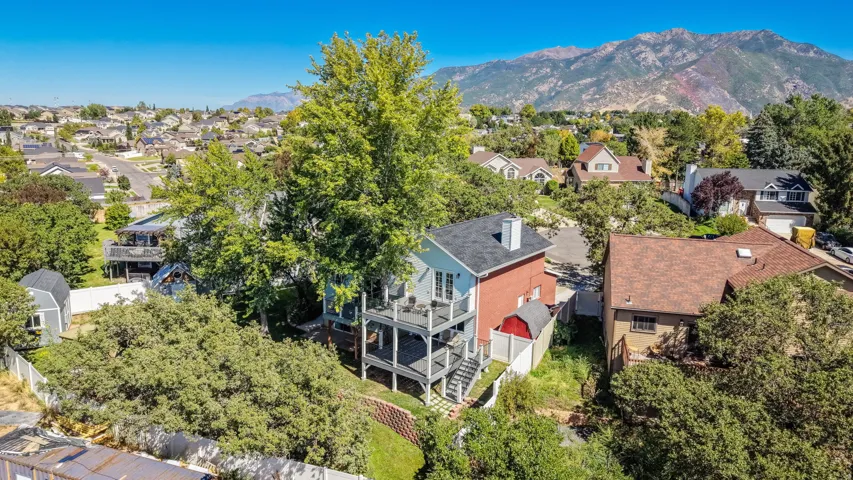 Two-story residence with a multi-level deck and a detached storage shed
