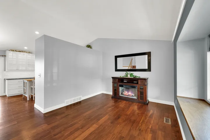 Wood-finish flooring, recessed lighting, built-in fireplace, and a window seat