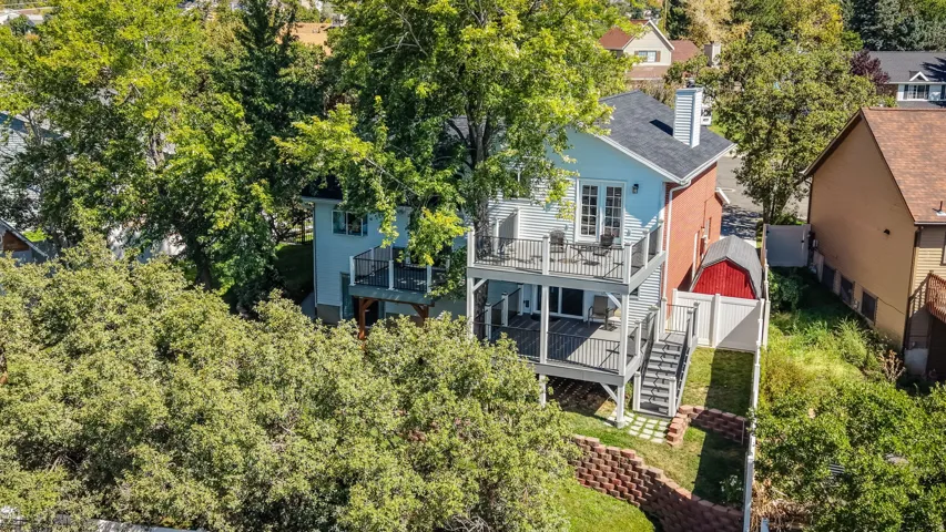 Multi-level deck with dark railings, exterior stairs, and a red shed