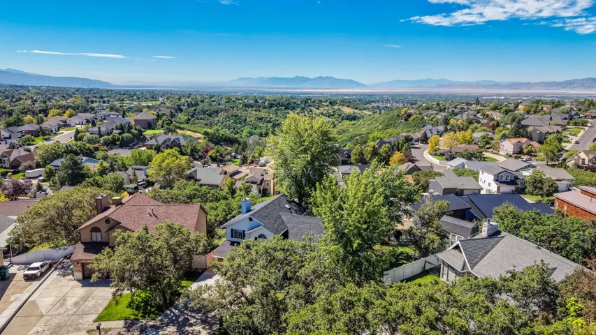 Residential area with expansive surrounding green spaces and distant mountain ranges