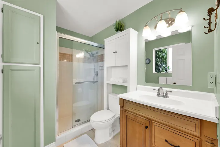 Enclosed shower with glass sliding doors and tiled surround