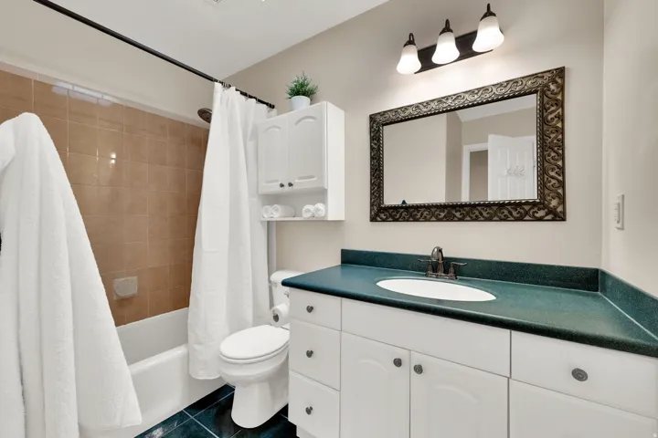 White vanity with a dark countertop and undermount sink