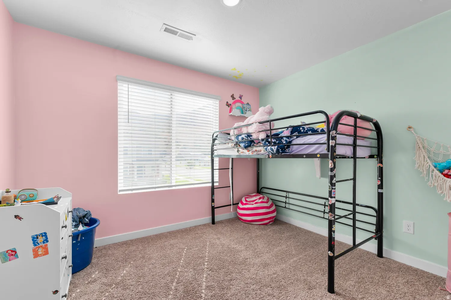 Recessed ceiling lighting, a large window with blinds, and wall-to-wall carpeting