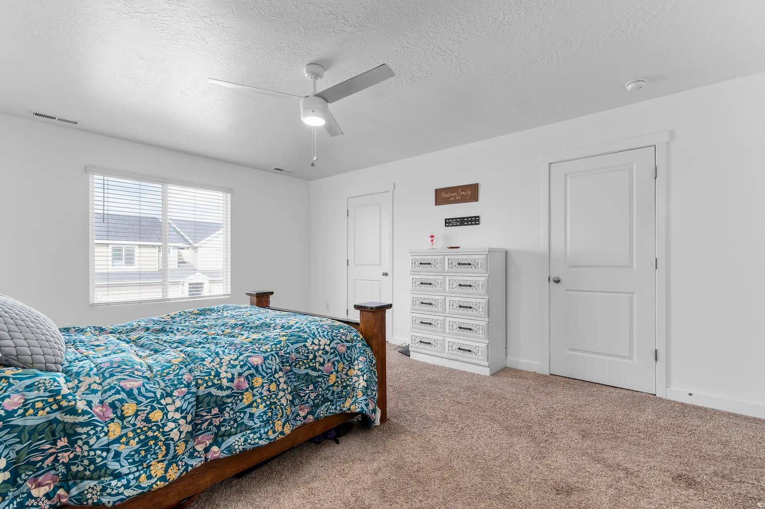 Recessed window with blinds, overhead ceiling fan with lighting, wall-to-wall carpeting, and white interior doors