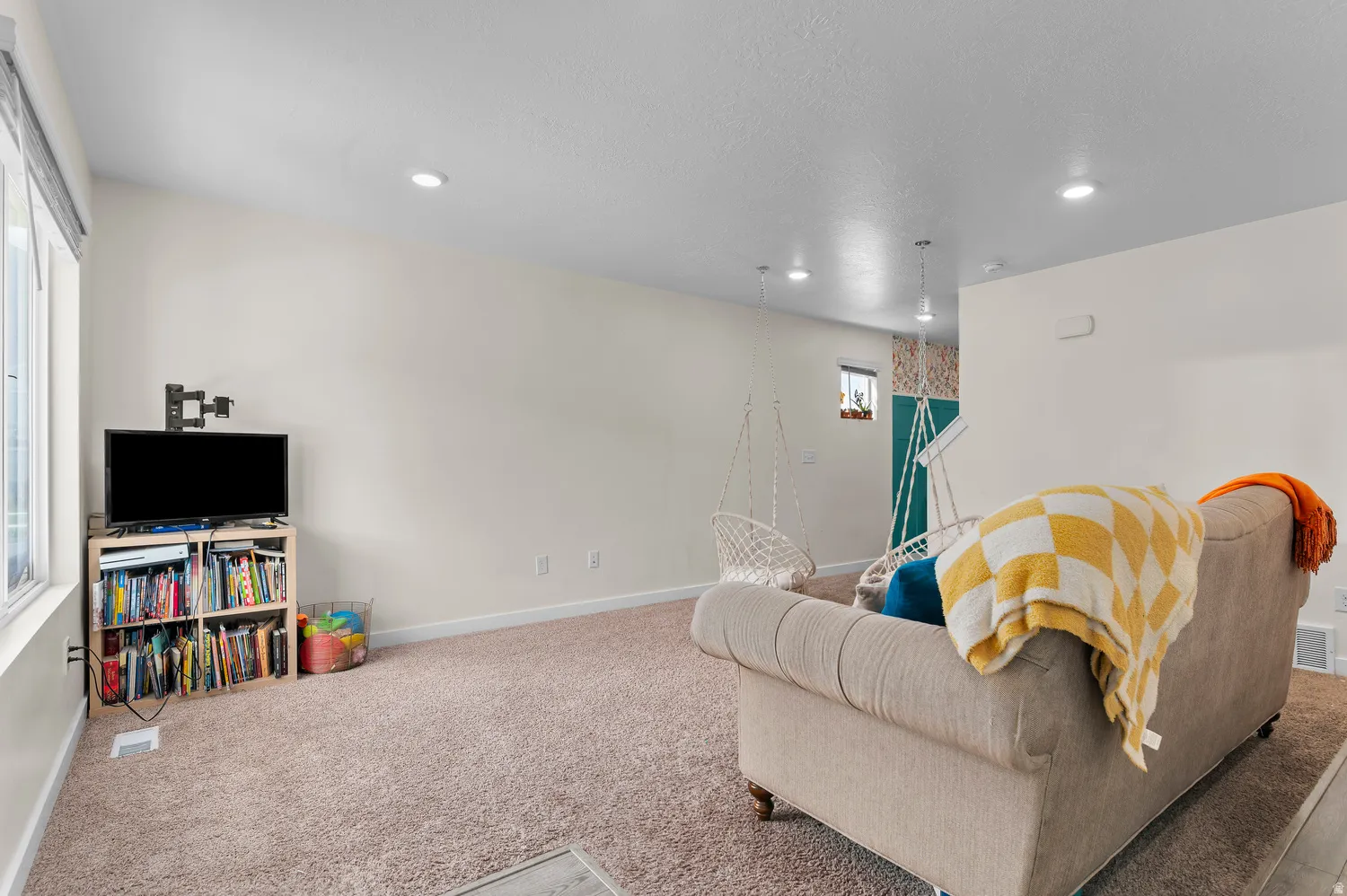 Wall-to-wall carpeting with recessed lighting and a window