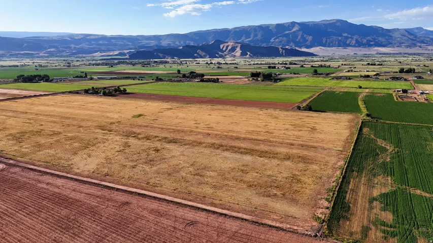 Expansive agricultural land featuring varied cultivated fields and distant mountain scenery