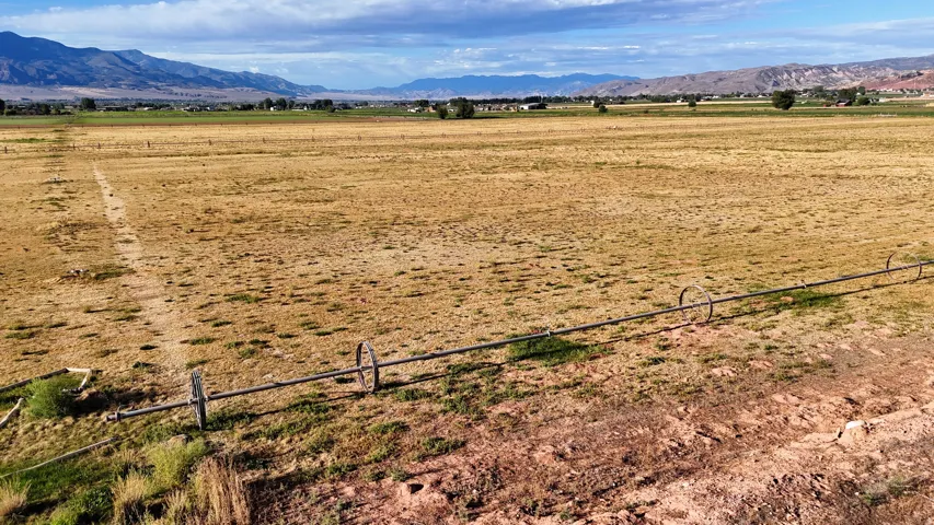 Expansive open field with an irrigation system, surrounded by distant mountains