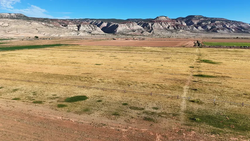 Expansive land parcel featuring open fields and a distant mountain range backdrop