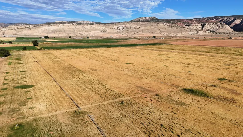 Expansive acreage with cultivated fields and distant mountain ranges