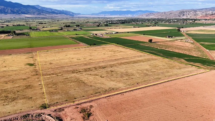 Expansive land parcel with surrounding agricultural fields and distant mountain scenery