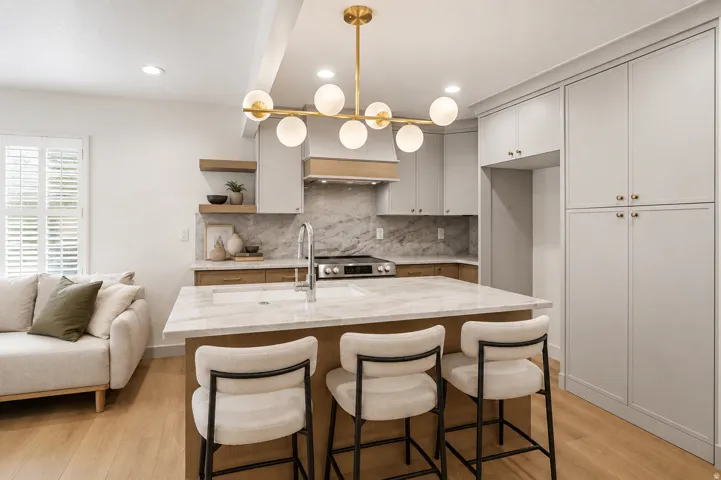 Kitchen featuring a large island with a surface, a built-in sink, and bar seating