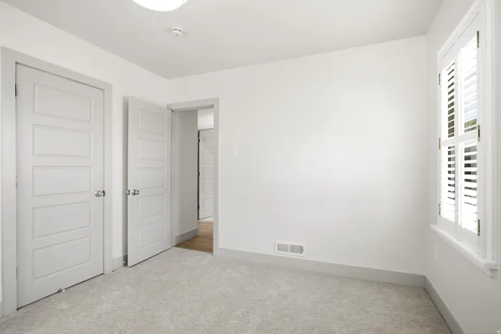 Plush carpeted flooring, white walls, and white trim