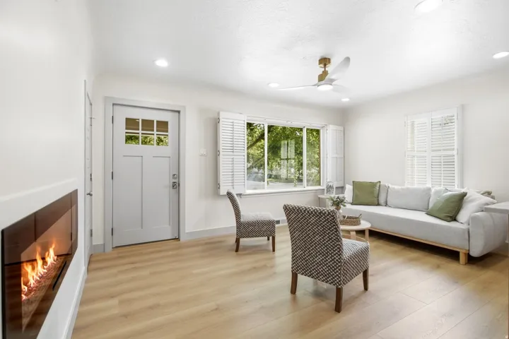 Recessed lighting, wood-finish flooring, ceiling fan, built-in fireplace, and transom window on entry door