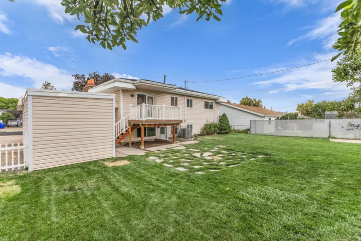 Expansive green lawn with a white picket fence