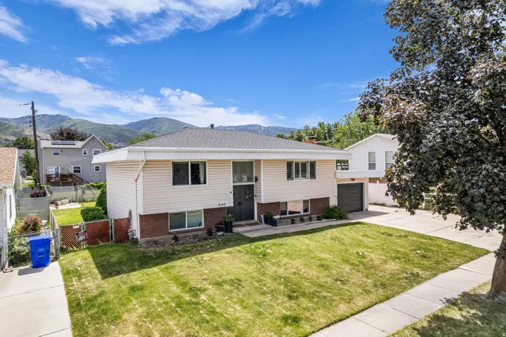 Two-story residence featuring light-colored siding and a dark roof