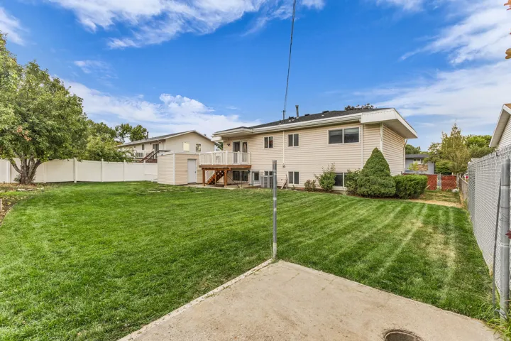 Expansive grassy yard framed by a white vinyl fence