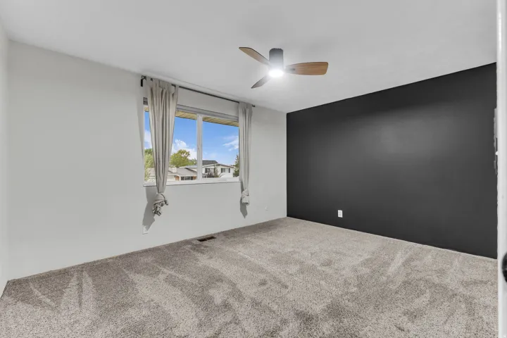Recessed window with white trim, wood-look ceiling fan with integrated lighting, and a dark accent wall