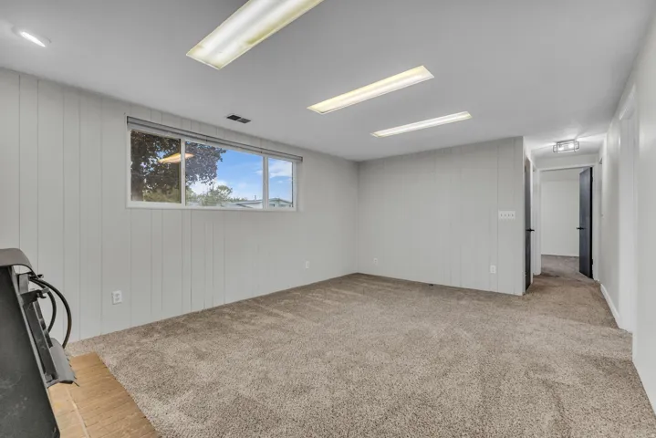 Wall-to-wall carpeting, white paneled walls, and recessed lighting