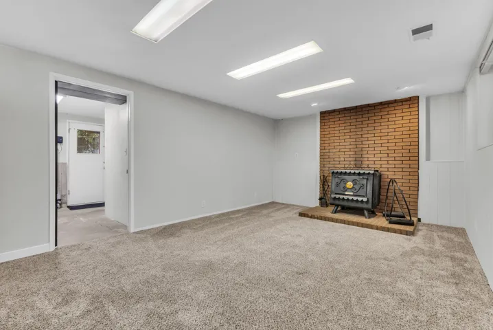 Brick accent wall with a cast iron wood-burning stove on a raised hearth