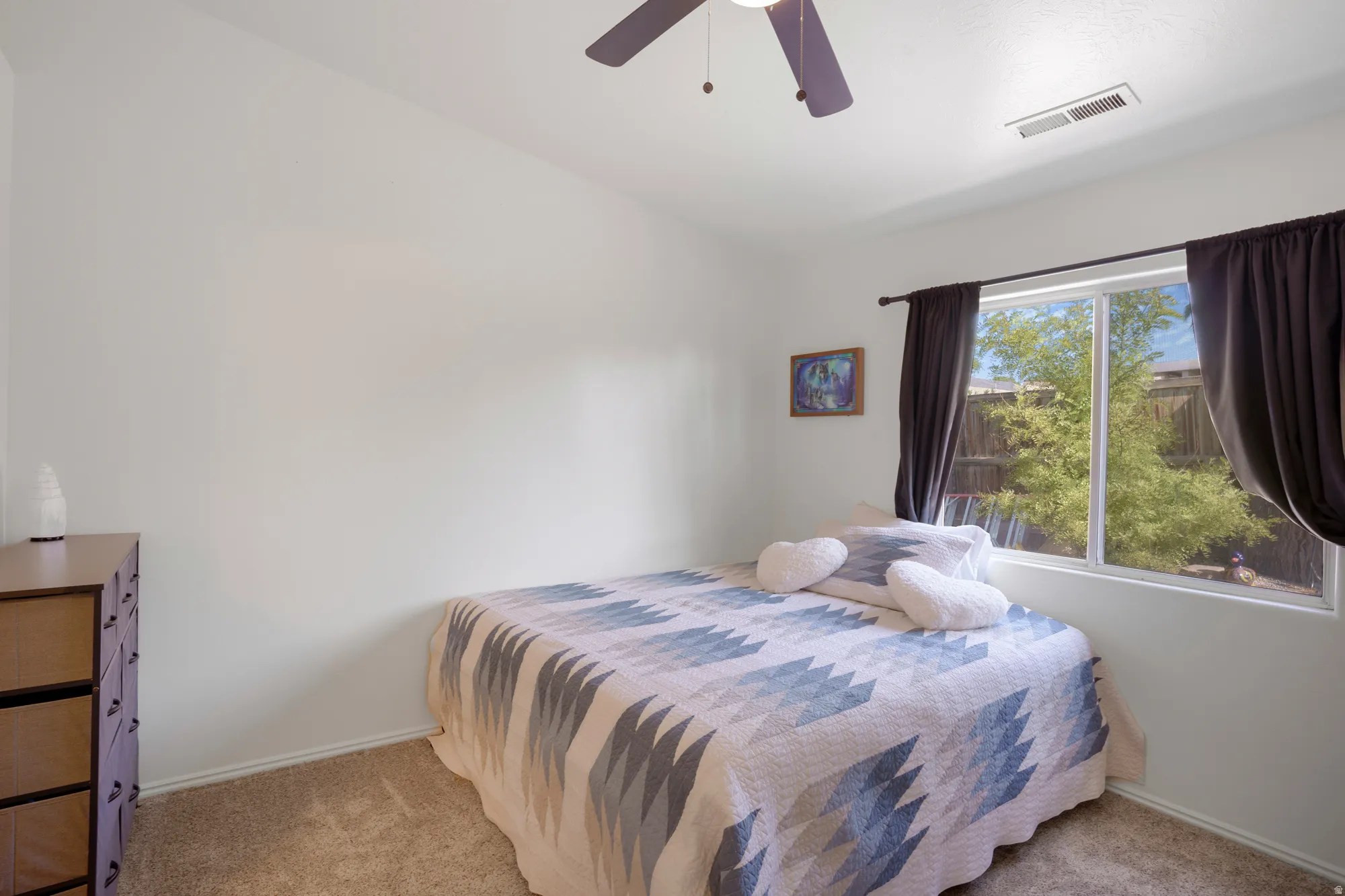 Bright interior with a ceiling fan, carpet flooring, and a large window