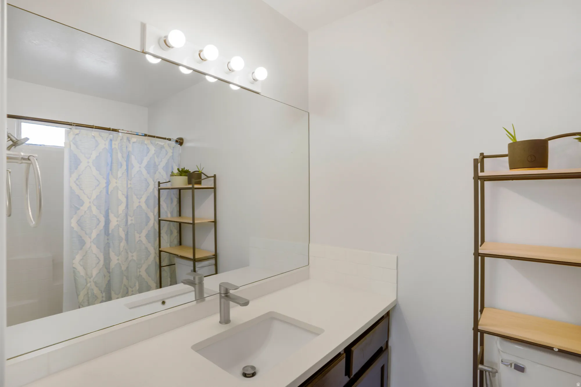 White countertop with an integrated rectangular sink, single-handle faucet, and dark-finish vanity