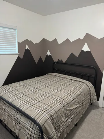 Textured wall treatment, window with horizontal blinds, neutral wall paint, and gray carpeting