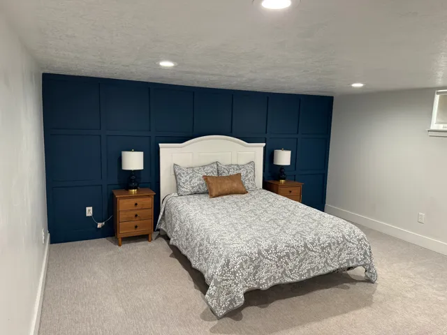 Accent wall with panel molding, recessed lighting, white trim, and light gray carpet