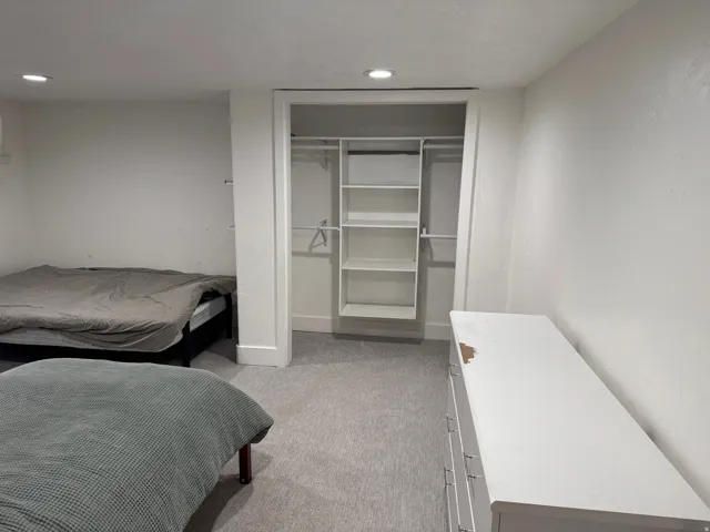 Recessed lighting, light gray carpeting, and integrated closet shelving