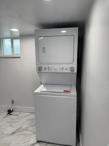 Stackable washer and dryer unit, recessed lighting, and patterned floor tile