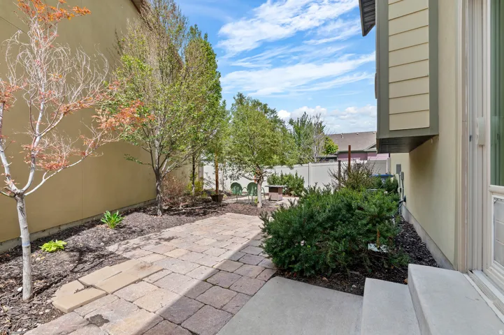 Paver patio area with planted trees and landscaping