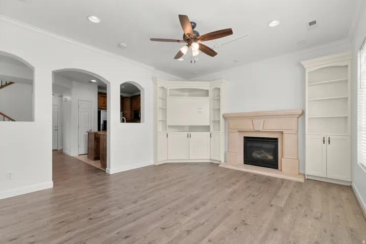 Light wood-finish flooring throughout, recessed lighting, and crown molding