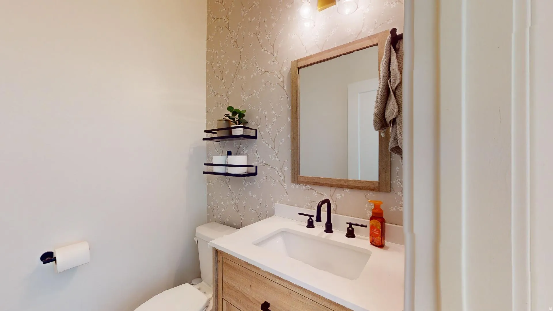 Vanity with white countertop, undermount sink, and matte black faucet