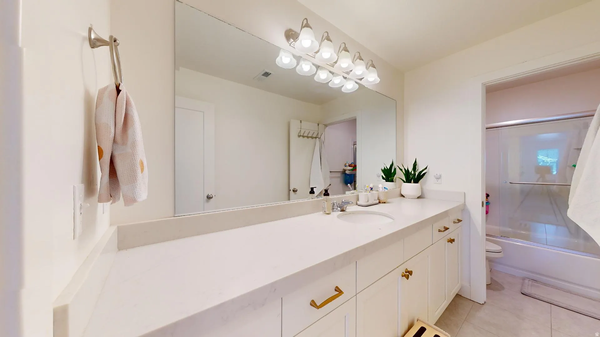 Extended vanity with an integrated sink, polished countertop, and ample storage cabinetry
