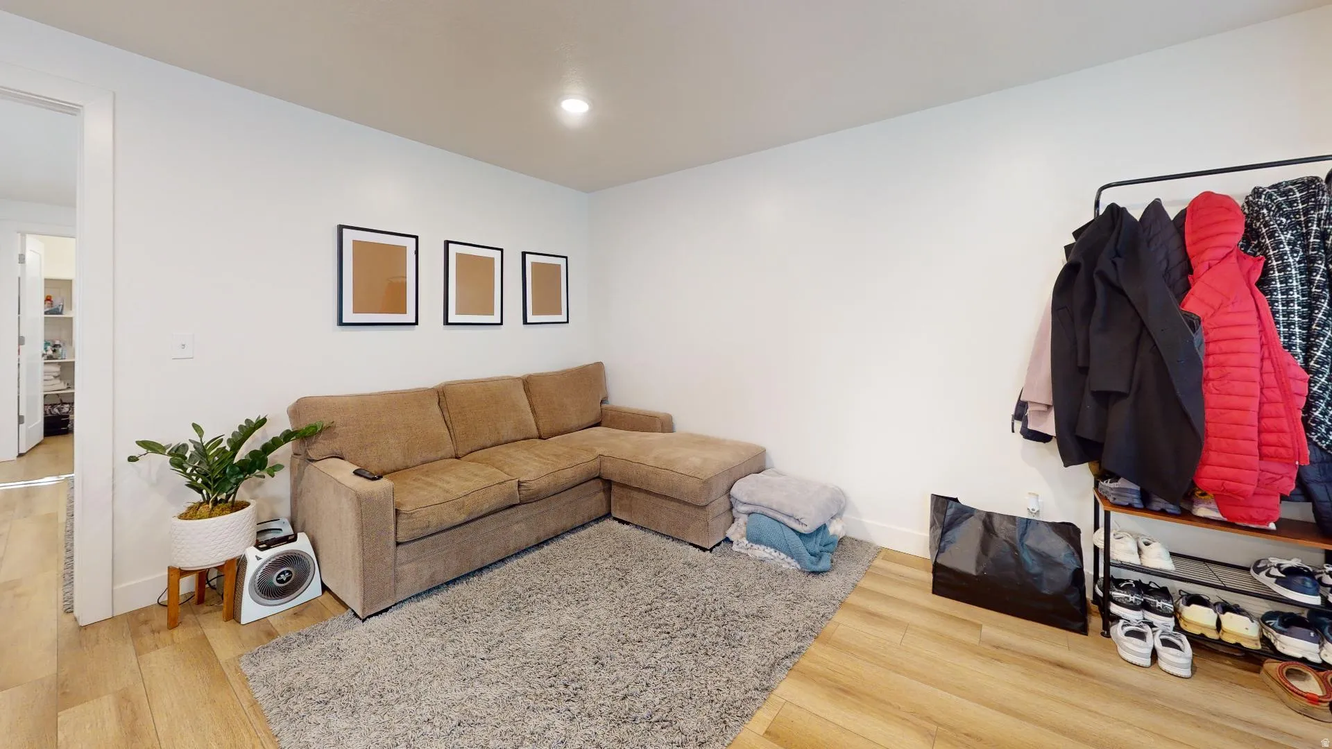 Recessed lighting, light wood-finish flooring, and white walls