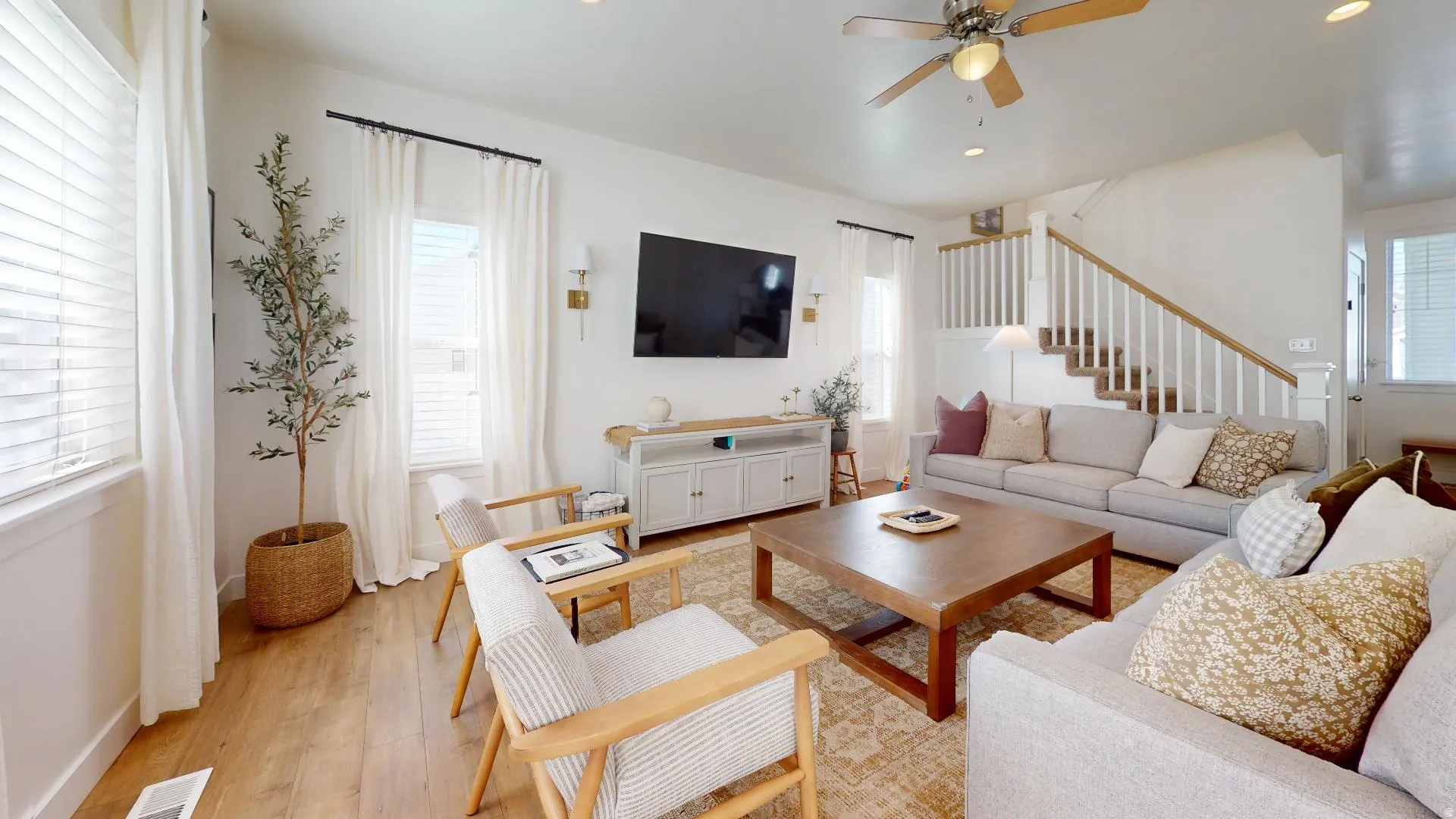 Spacious living area featuring wood-finish flooring, recessed lighting, and a ceiling fan