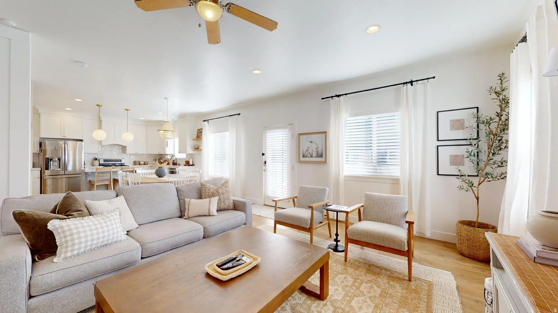 Open-concept living area with wood-finish flooring, recessed lighting, and a ceiling fan
