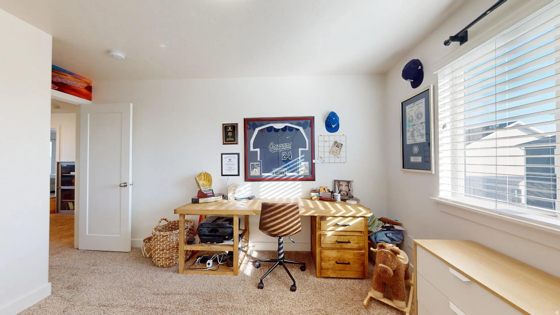 Carpeted flooring with white wall finishes, a white single-panel door, and a window with horizontal blinds