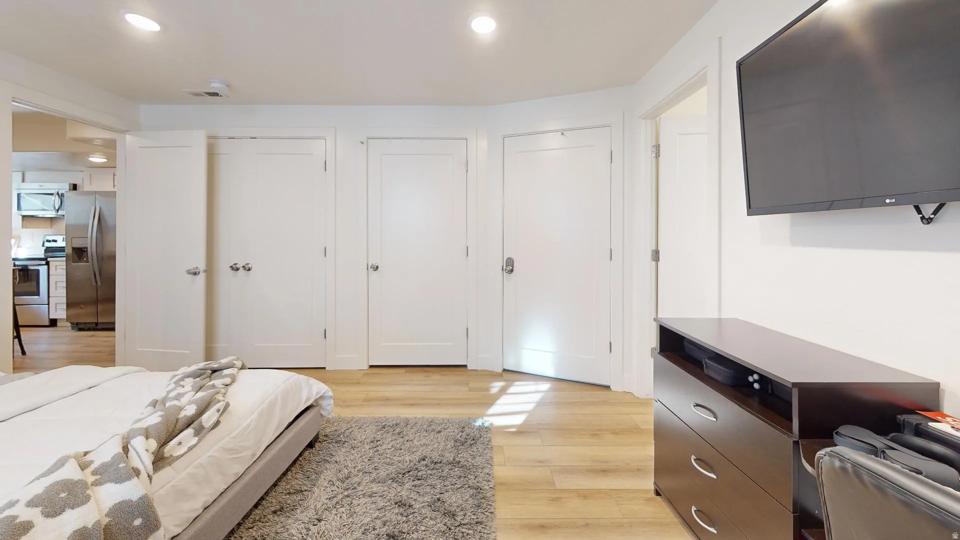 Recessed lighting, wood-finish flooring, and white interior doors